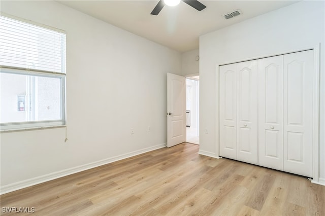 unfurnished bedroom with ceiling fan, light hardwood / wood-style floors, and a closet