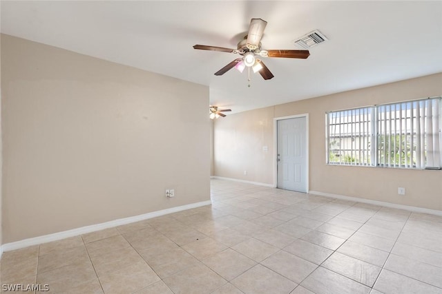 spare room featuring baseboards, visible vents, a ceiling fan, and light tile patterned flooring