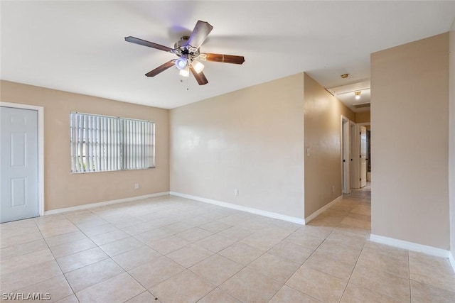 unfurnished room featuring light tile patterned floors, a ceiling fan, and baseboards