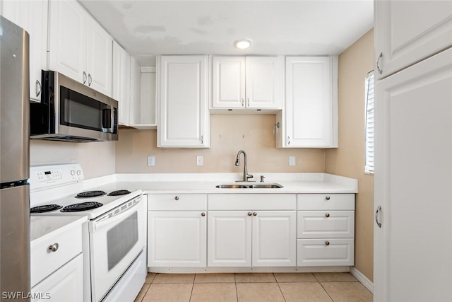 kitchen with light countertops, appliances with stainless steel finishes, a sink, and white cabinets