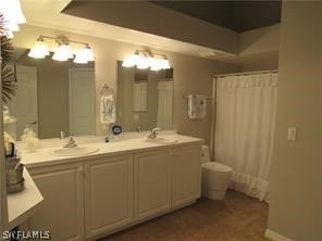 bathroom with dual vanity and a chandelier