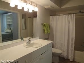 full bathroom with vanity, shower / bath combo with shower curtain, and toilet