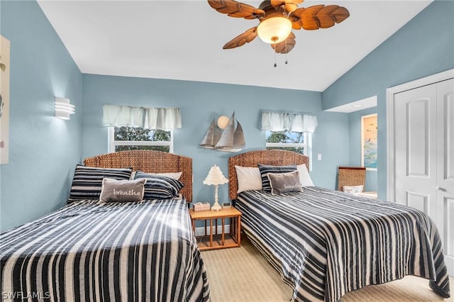 carpeted bedroom featuring ceiling fan, vaulted ceiling, and a closet