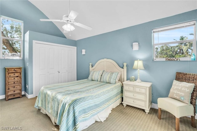 bedroom with a ceiling fan, a closet, baseboards, light colored carpet, and lofted ceiling