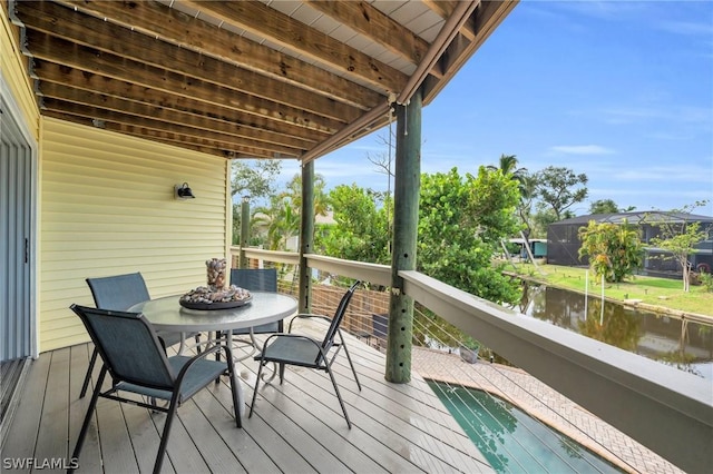 wooden terrace featuring a water view and a fire pit