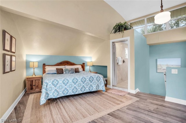 bedroom with baseboards, wood finished floors, and lofted ceiling