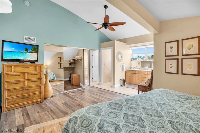 bedroom with ensuite bathroom, ceiling fan, high vaulted ceiling, light hardwood / wood-style floors, and a closet