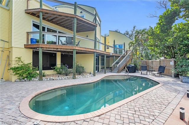 rear view of house featuring stairs, a patio, stucco siding, and fence