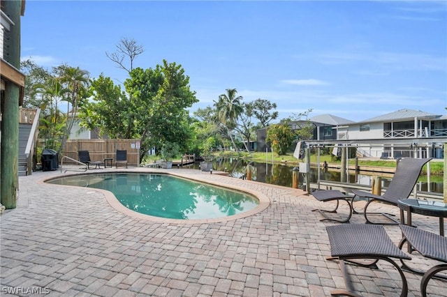 view of swimming pool with a patio, a water view, fence, and a fenced in pool