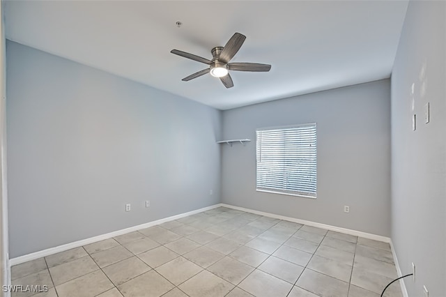 spare room with a ceiling fan and baseboards