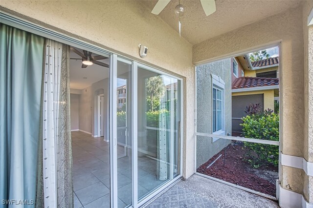 view of exterior entry with ceiling fan and stucco siding