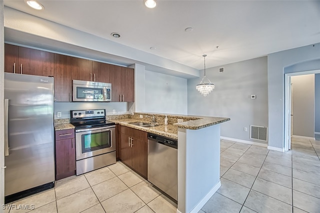 kitchen with visible vents, appliances with stainless steel finishes, a peninsula, a sink, and light tile patterned flooring