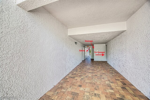 interior space featuring brick floor and a textured wall