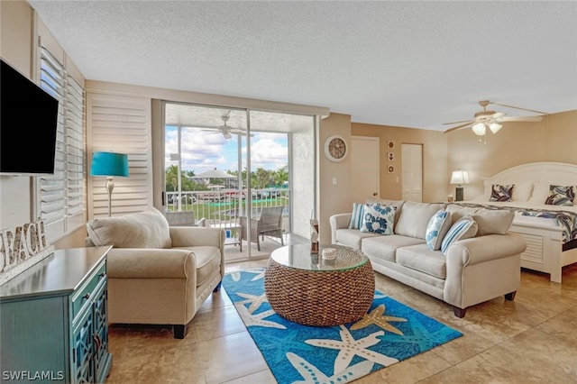 living room with a textured ceiling, ceiling fan, and light tile patterned flooring