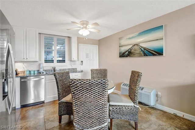 tiled dining room with sink, a textured ceiling, and ceiling fan