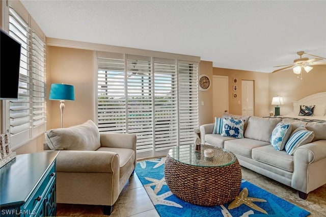 living room featuring light tile patterned floors, a textured ceiling, and ceiling fan