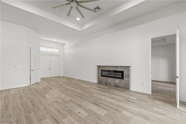 unfurnished living room featuring ceiling fan, a fireplace, and light wood-type flooring