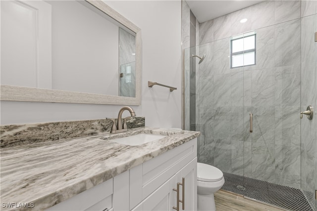 bathroom featuring hardwood / wood-style flooring, vanity, toilet, and an enclosed shower