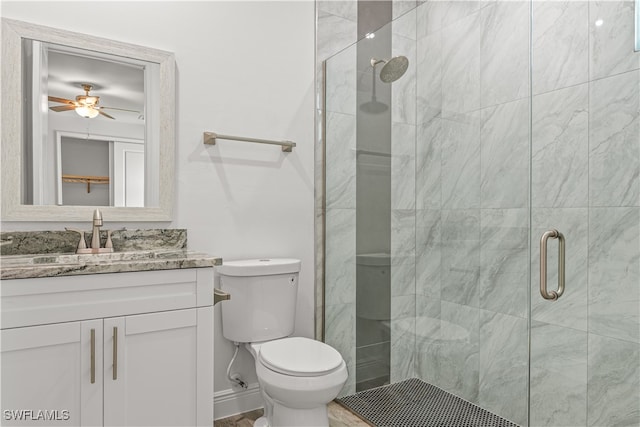 bathroom with ceiling fan, a shower with door, vanity, and toilet