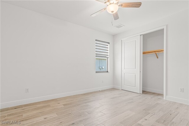 unfurnished bedroom with ceiling fan, light wood-type flooring, and a closet