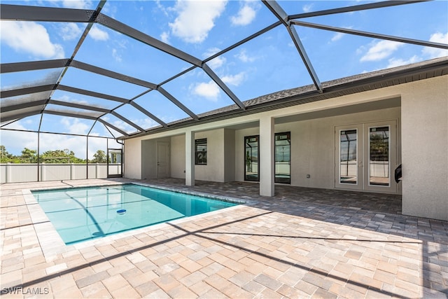 view of swimming pool featuring french doors, a patio area, and a lanai