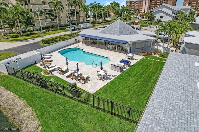 community pool with a fenced backyard, a lawn, and a patio