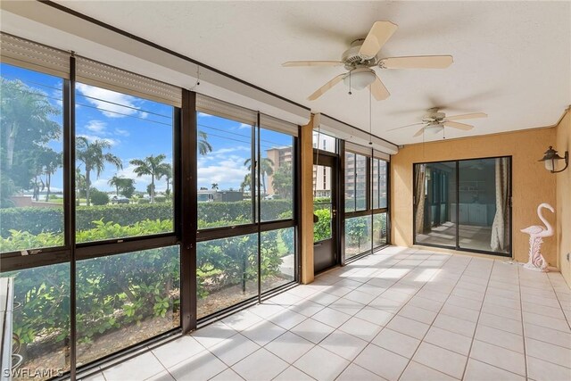 unfurnished sunroom featuring ceiling fan