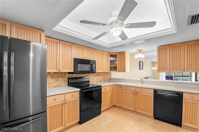 kitchen with a tray ceiling, light countertops, visible vents, glass insert cabinets, and black appliances