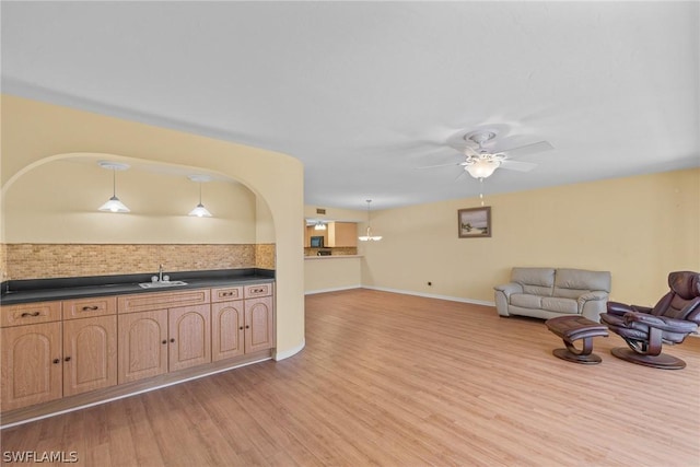 living room with light wood-style floors, ceiling fan, and baseboards