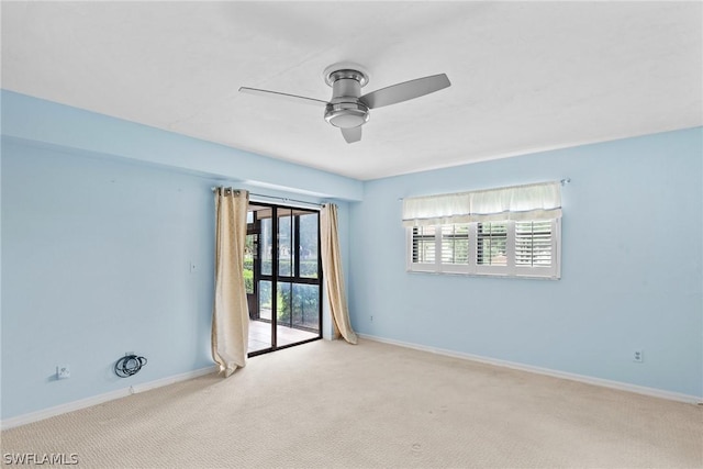 spare room with light colored carpet, ceiling fan, and baseboards