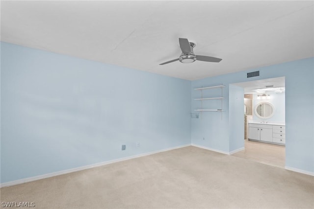 unfurnished bedroom featuring visible vents, ensuite bathroom, a ceiling fan, light carpet, and baseboards