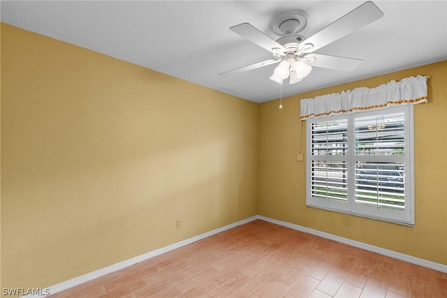 spare room with light wood-style floors, ceiling fan, and baseboards