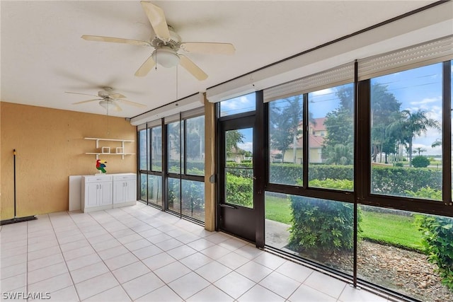 unfurnished sunroom with ceiling fan