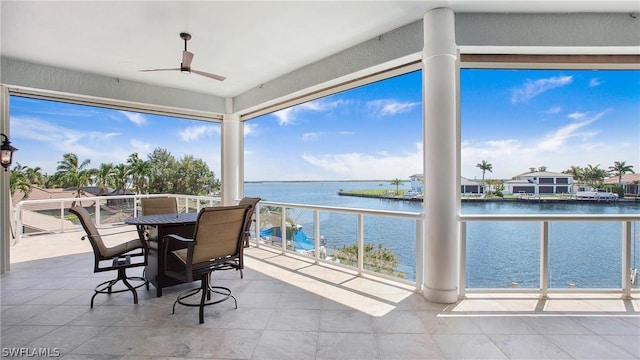 sunroom / solarium with ceiling fan and a water view