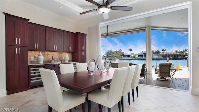 dining space with light tile patterned flooring, ornamental molding, and a water view