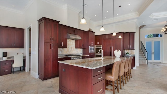 kitchen with a large island, tasteful backsplash, and hanging light fixtures