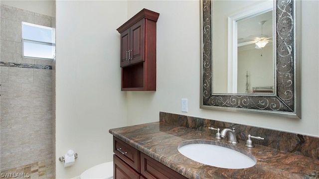 bathroom with toilet, ceiling fan, and vanity