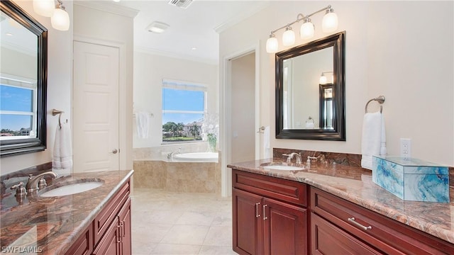 bathroom featuring tile patterned flooring, crown molding, tiled tub, and vanity