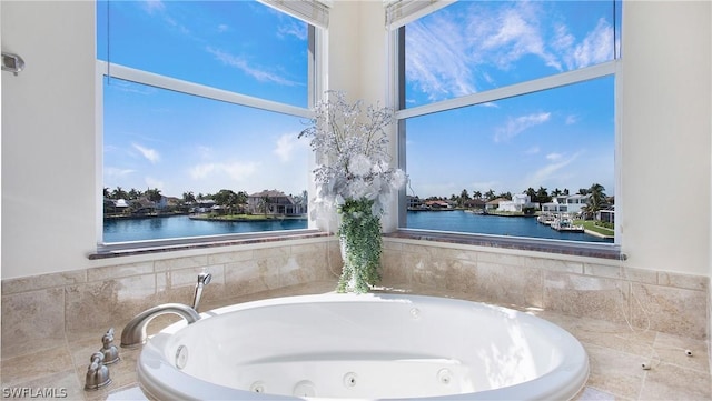 bathroom with a bath, a wealth of natural light, and a water view