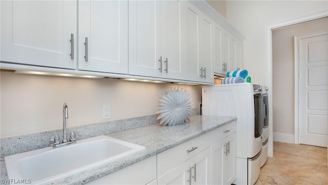 laundry room featuring sink, washer and dryer, and cabinets