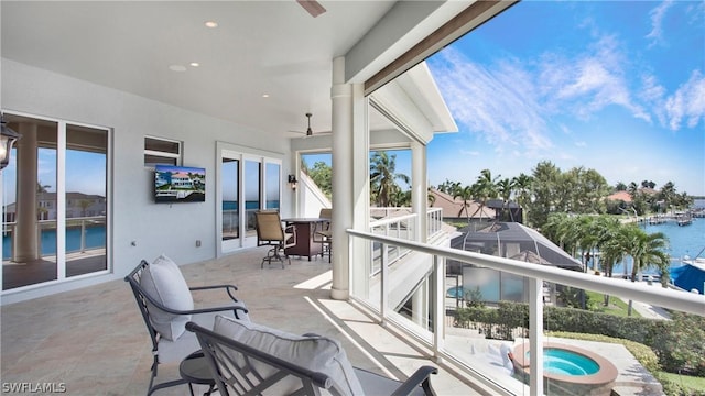 balcony featuring ceiling fan and a water view