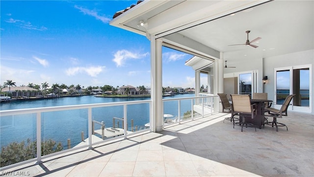 view of patio featuring a balcony, ceiling fan, and a water view