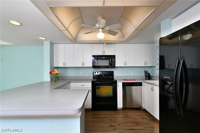 kitchen with dark wood-type flooring, ceiling fan, white cabinetry, black appliances, and kitchen peninsula