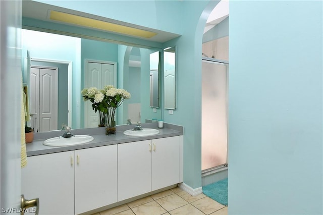 bathroom featuring tile patterned flooring, vanity, and walk in shower