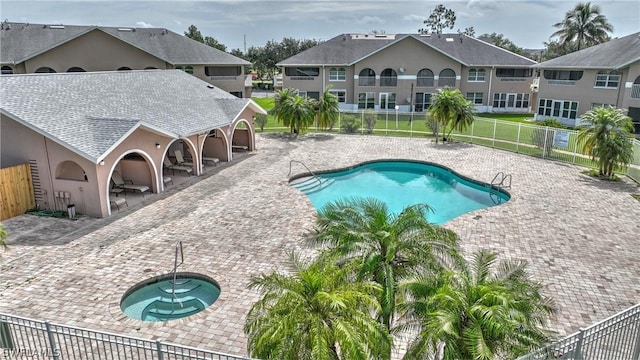 view of swimming pool with a community hot tub and a patio area