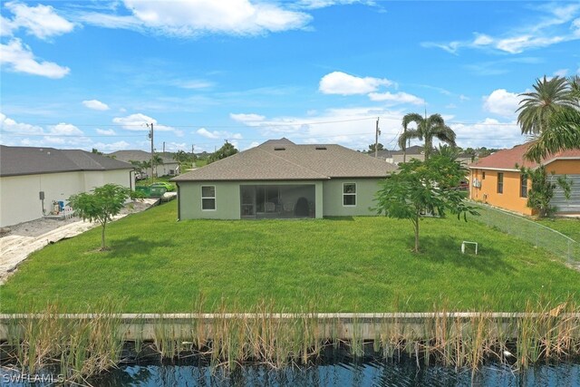 rear view of property with a yard and a water view