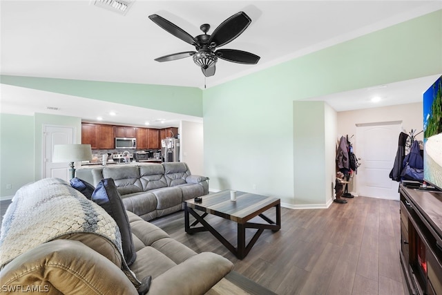 living room featuring dark hardwood / wood-style floors, vaulted ceiling, and ceiling fan