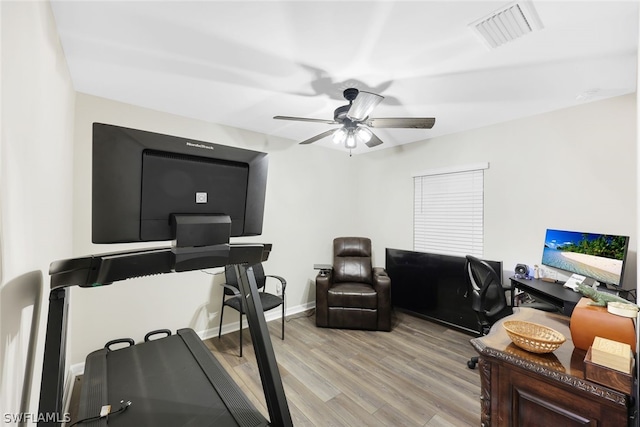 workout room featuring ceiling fan and light hardwood / wood-style flooring