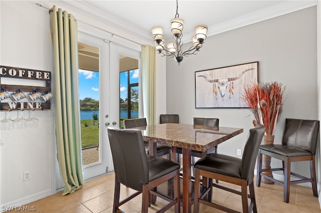 tiled dining space featuring a water view, crown molding, a chandelier, and french doors