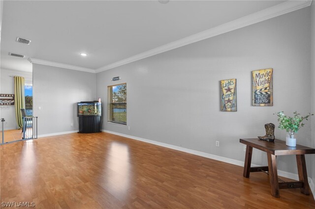 unfurnished living room featuring crown molding, hardwood / wood-style floors, and a wealth of natural light